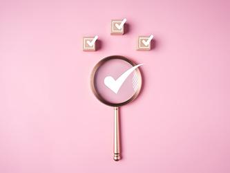 magnifying glass with a white tick mark inside it and three tick boxes above